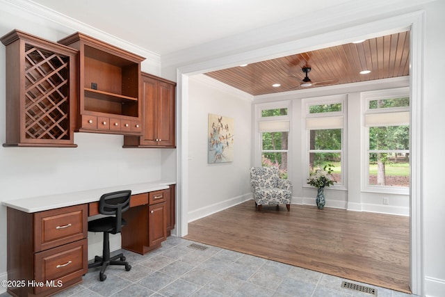 office space featuring crown molding, ceiling fan, built in desk, and wood ceiling