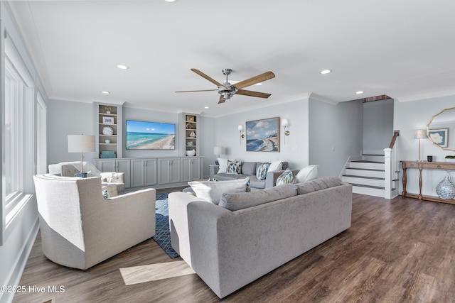 living room featuring dark wood-type flooring, ceiling fan, ornamental molding, and built in shelves