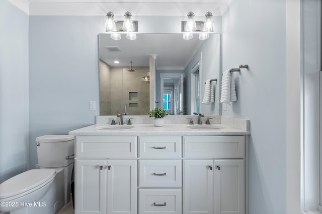 bathroom with vanity, crown molding, a shower with shower door, and toilet