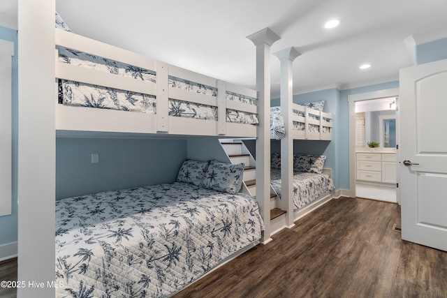 bedroom with ensuite bath, dark hardwood / wood-style floors, and decorative columns