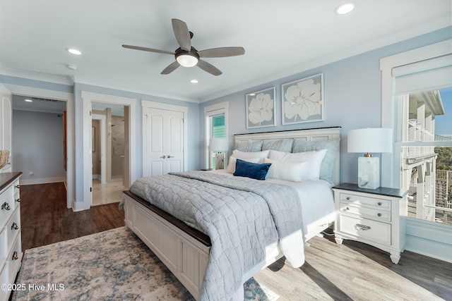 bedroom featuring dark wood-type flooring, ceiling fan, crown molding, and a closet