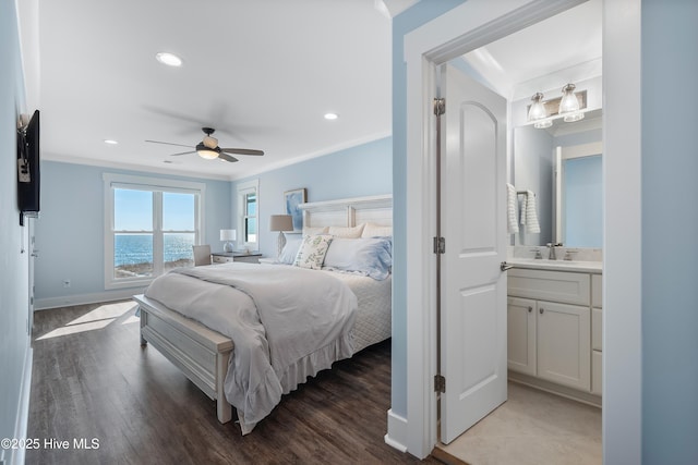 bedroom with sink, hardwood / wood-style flooring, ceiling fan, crown molding, and a water view