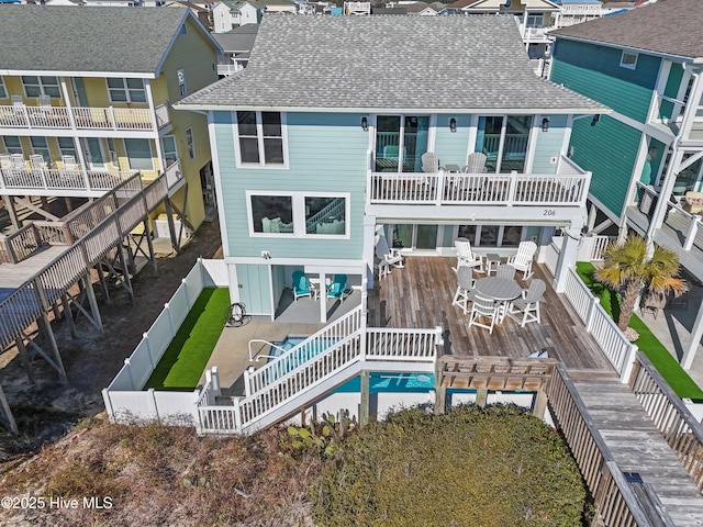 back of property with a balcony and a deck