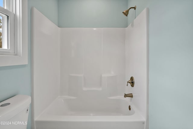 bathroom with washtub / shower combination and toilet