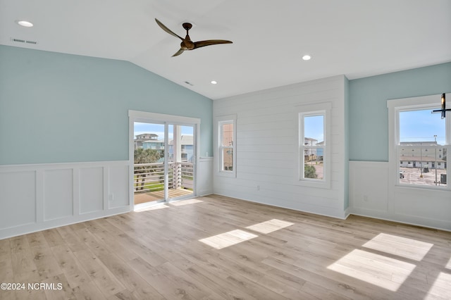 empty room featuring ceiling fan, light hardwood / wood-style flooring, and lofted ceiling