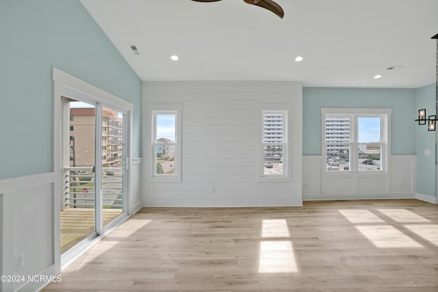 unfurnished room featuring ceiling fan, light hardwood / wood-style flooring, and lofted ceiling