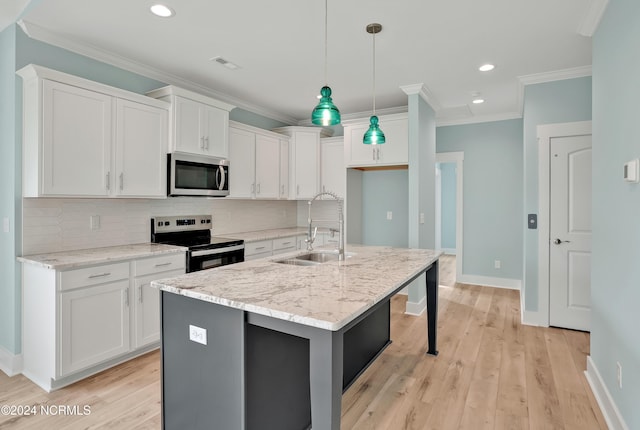 kitchen with sink, white cabinetry, appliances with stainless steel finishes, and a center island with sink