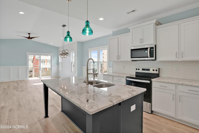 kitchen with pendant lighting, sink, white cabinets, an island with sink, and stainless steel appliances