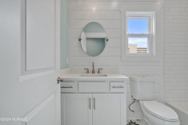 bathroom with wooden walls, toilet, and vanity