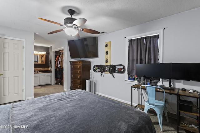 carpeted bedroom featuring ensuite bath, a textured ceiling, radiator heating unit, a closet, and ceiling fan