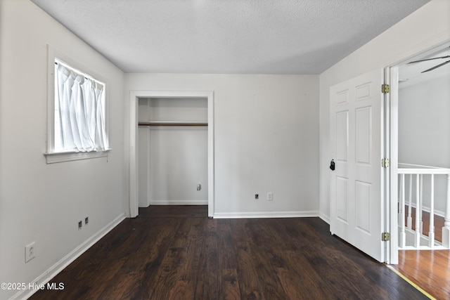 unfurnished bedroom featuring dark hardwood / wood-style flooring and a textured ceiling