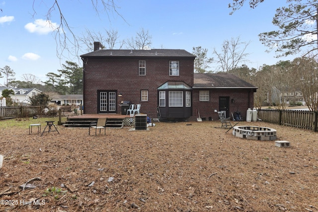 back of property with a wooden deck and an outdoor fire pit