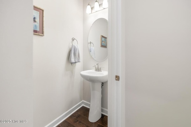 1512 Grove Ln, Wilmington, NC 28409 - bathroom featuring wood finished floors, baseboards, and a sink