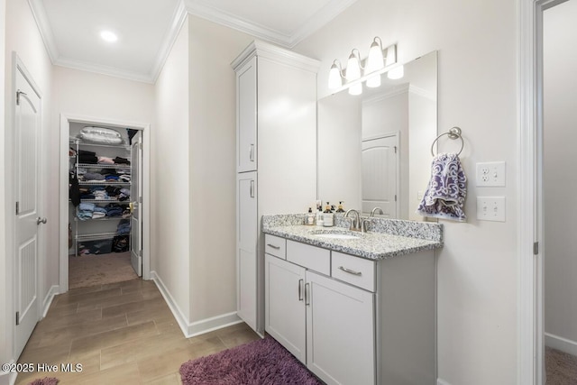 1512 Grove Ln, Wilmington, NC 28409 - bathroom featuring vanity, crown molding, wood finished floors, a spacious closet, and baseboards