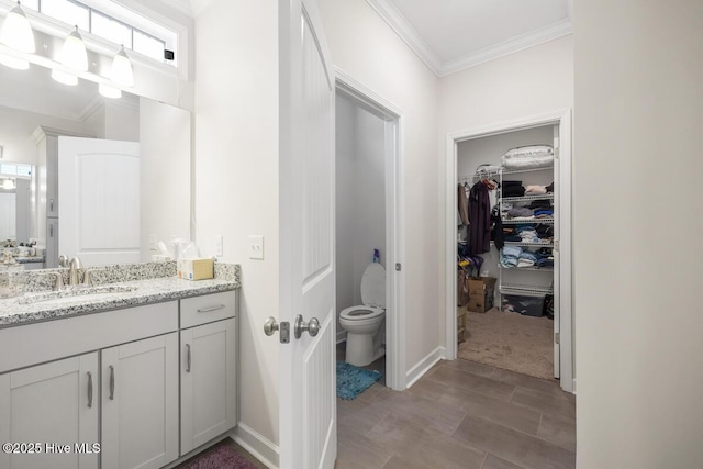 bathroom featuring toilet, vanity, and crown molding