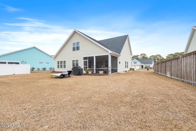 rear view of house featuring a lawn and a sunroom