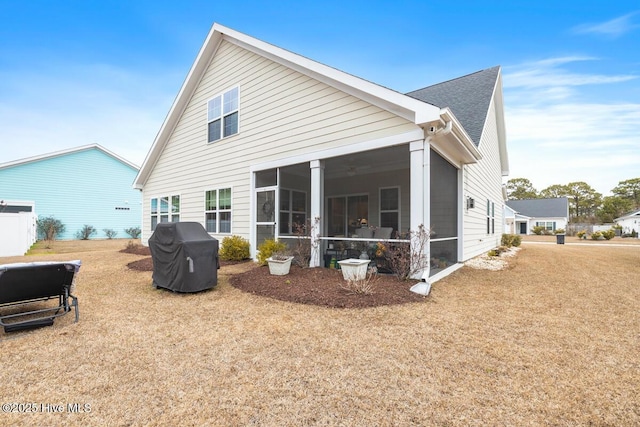 back of property featuring a sunroom and a yard