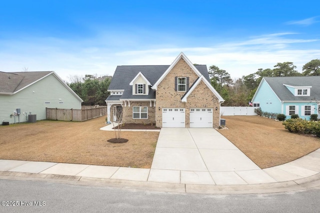 view of front of property with a garage, a front lawn, and central AC