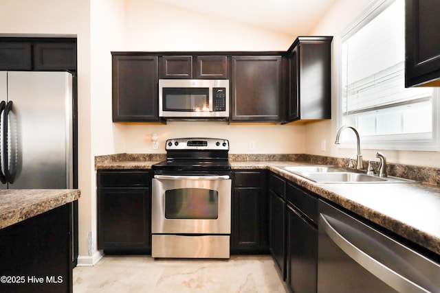 kitchen with lofted ceiling, sink, dark brown cabinets, and stainless steel appliances