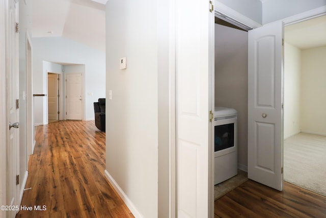 corridor with washer / dryer, dark wood-style flooring, and baseboards