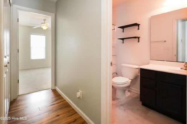 bathroom featuring hardwood / wood-style flooring, vanity, ceiling fan, and toilet