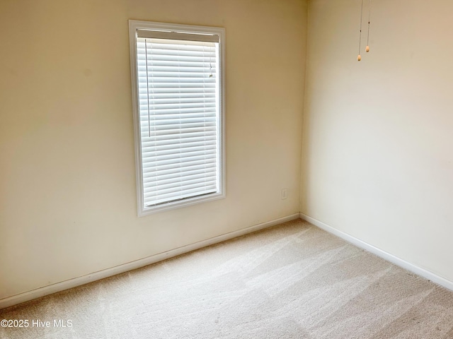 carpeted spare room with baseboards