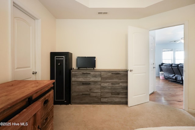 office space featuring light carpet, ceiling fan, and visible vents