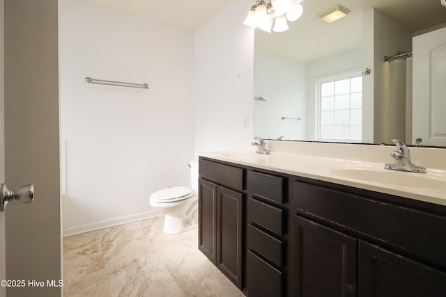 bathroom featuring toilet, double vanity, visible vents, and a sink