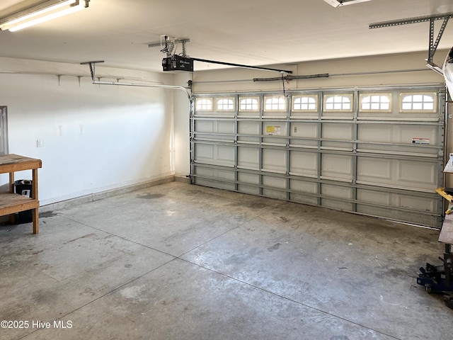 garage with a garage door opener and baseboards