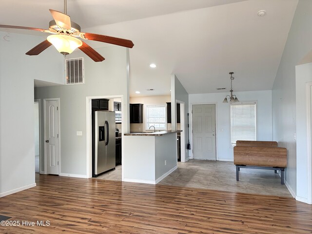 living room featuring hardwood / wood-style flooring, ceiling fan, a fireplace, and vaulted ceiling