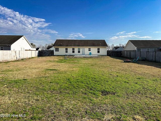 rear view of property with a yard and a fenced backyard