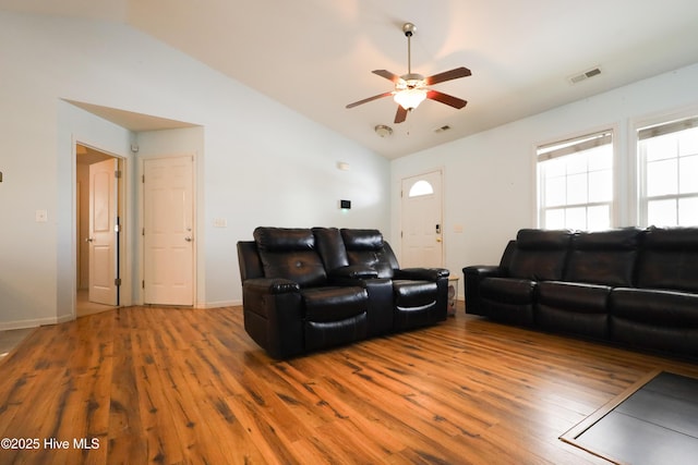 living room featuring lofted ceiling, wood finished floors, visible vents, and a ceiling fan