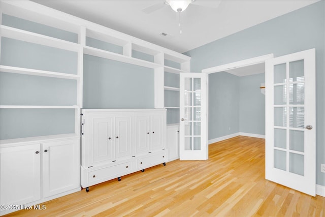 interior space with ceiling fan, wood-type flooring, and french doors