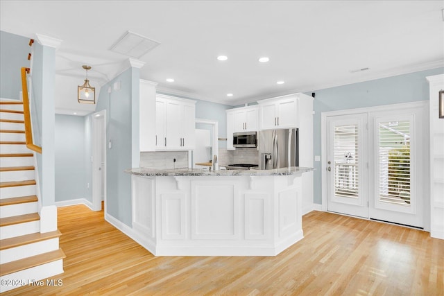 kitchen featuring white cabinetry, light hardwood / wood-style flooring, decorative backsplash, and stainless steel appliances