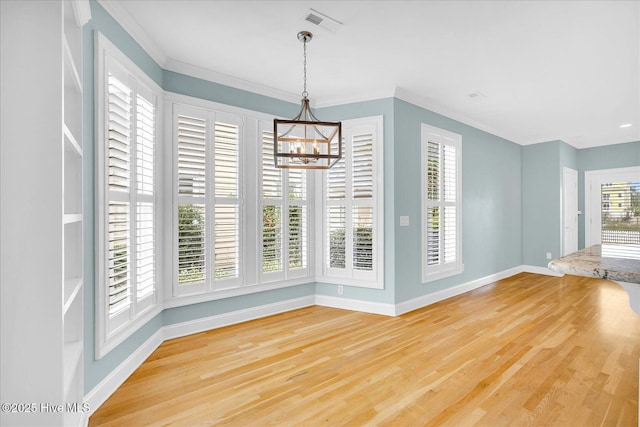 unfurnished dining area with a notable chandelier, hardwood / wood-style flooring, and ornamental molding