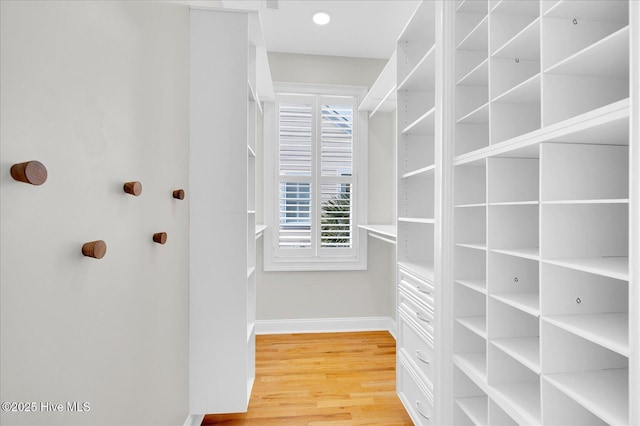 walk in closet with hardwood / wood-style floors