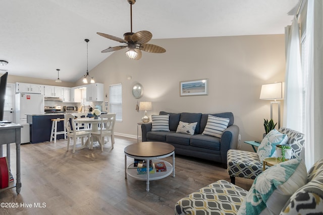 living room featuring a healthy amount of sunlight, hardwood / wood-style floors, high vaulted ceiling, and ceiling fan