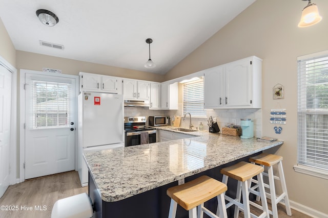 kitchen featuring pendant lighting, sink, stainless steel appliances, and white cabinets