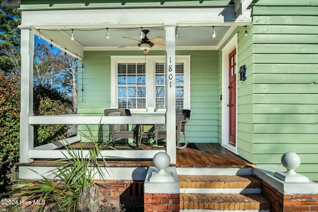 view of exterior entry featuring ceiling fan and covered porch