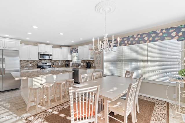 tiled dining space with sink and an inviting chandelier