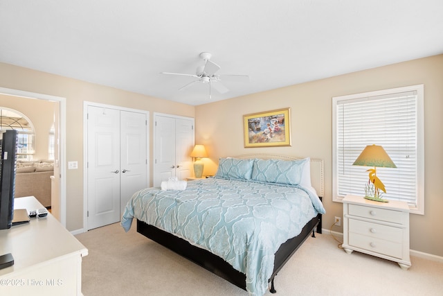 carpeted bedroom with multiple closets and ceiling fan