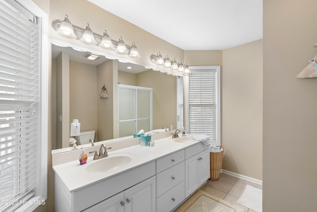 bathroom with toilet, a shower with shower door, tile patterned floors, and vanity