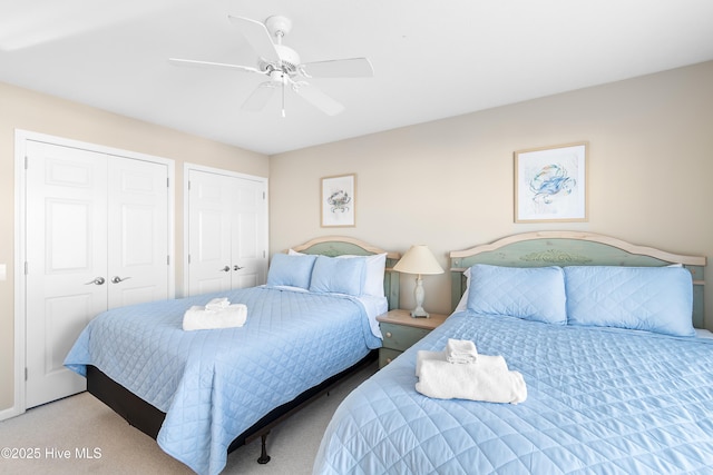 carpeted bedroom featuring multiple closets and ceiling fan