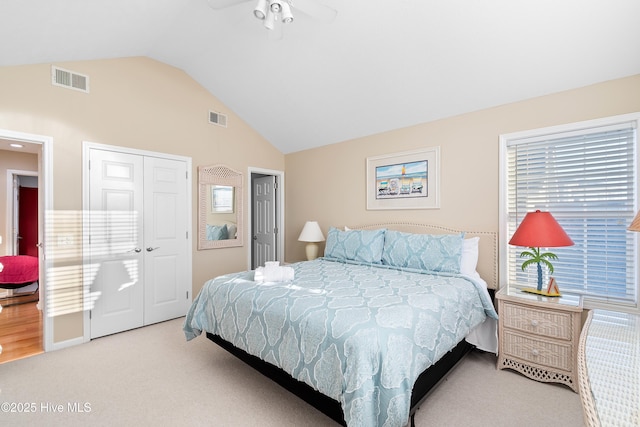 bedroom with light carpet, a closet, and lofted ceiling