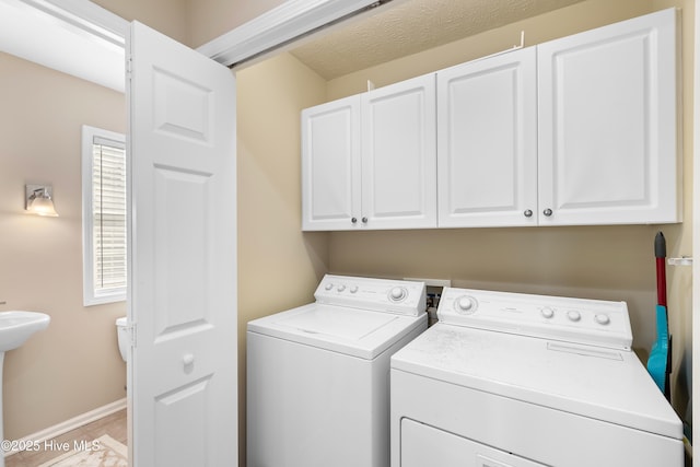 washroom featuring sink, cabinets, and washer and dryer