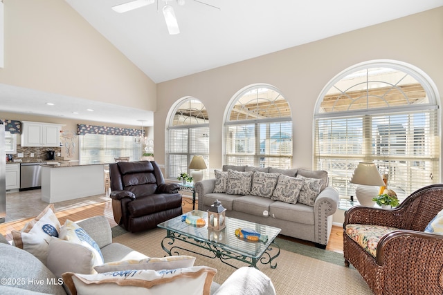 living room featuring light wood-type flooring, high vaulted ceiling, and ceiling fan