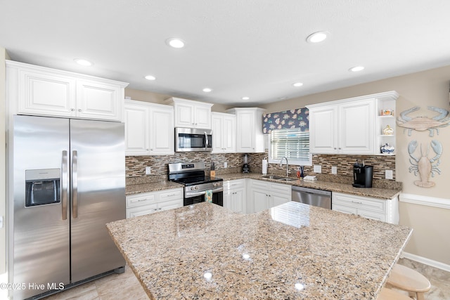 kitchen with sink, tasteful backsplash, white cabinetry, and appliances with stainless steel finishes