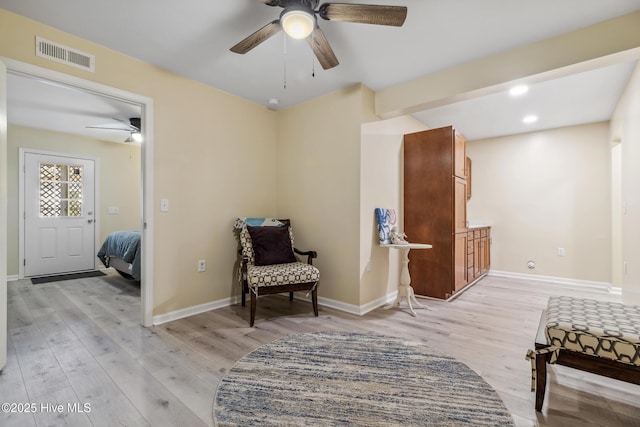 living area featuring ceiling fan and light wood-type flooring