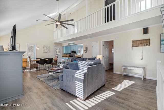 living room featuring hardwood / wood-style floors, plenty of natural light, high vaulted ceiling, and ceiling fan