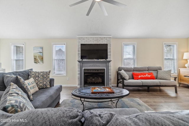 living room with ceiling fan, lofted ceiling, hardwood / wood-style floors, and a fireplace